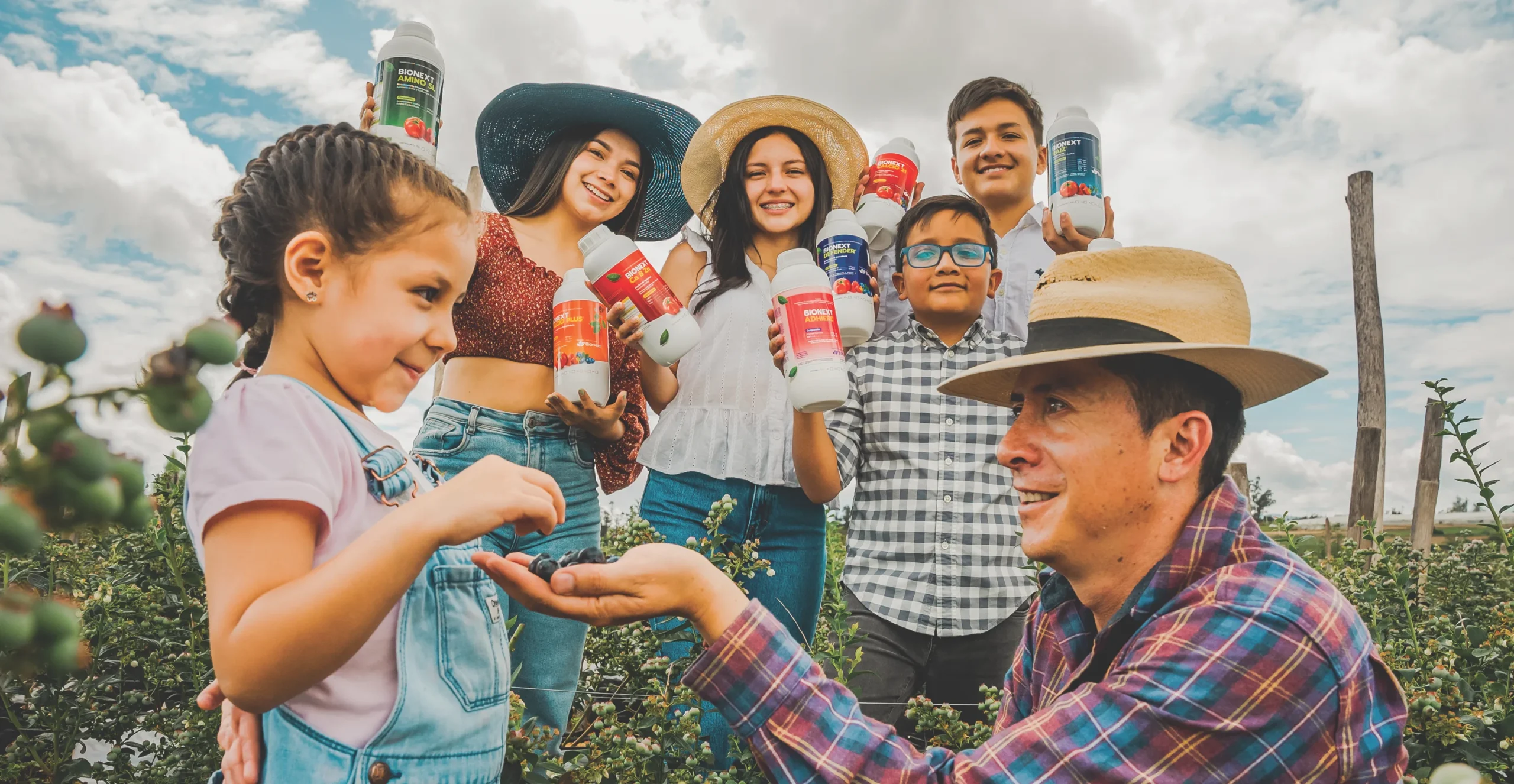 Familia de agricultores ecuatorianos con productos Bionext en cultivo de arándano